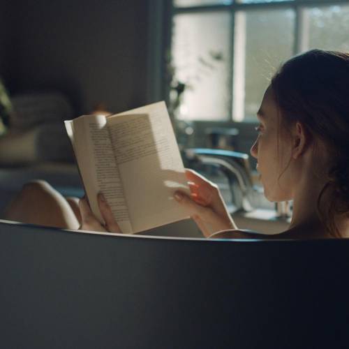 Mujer leyendo libro en bañera Roca